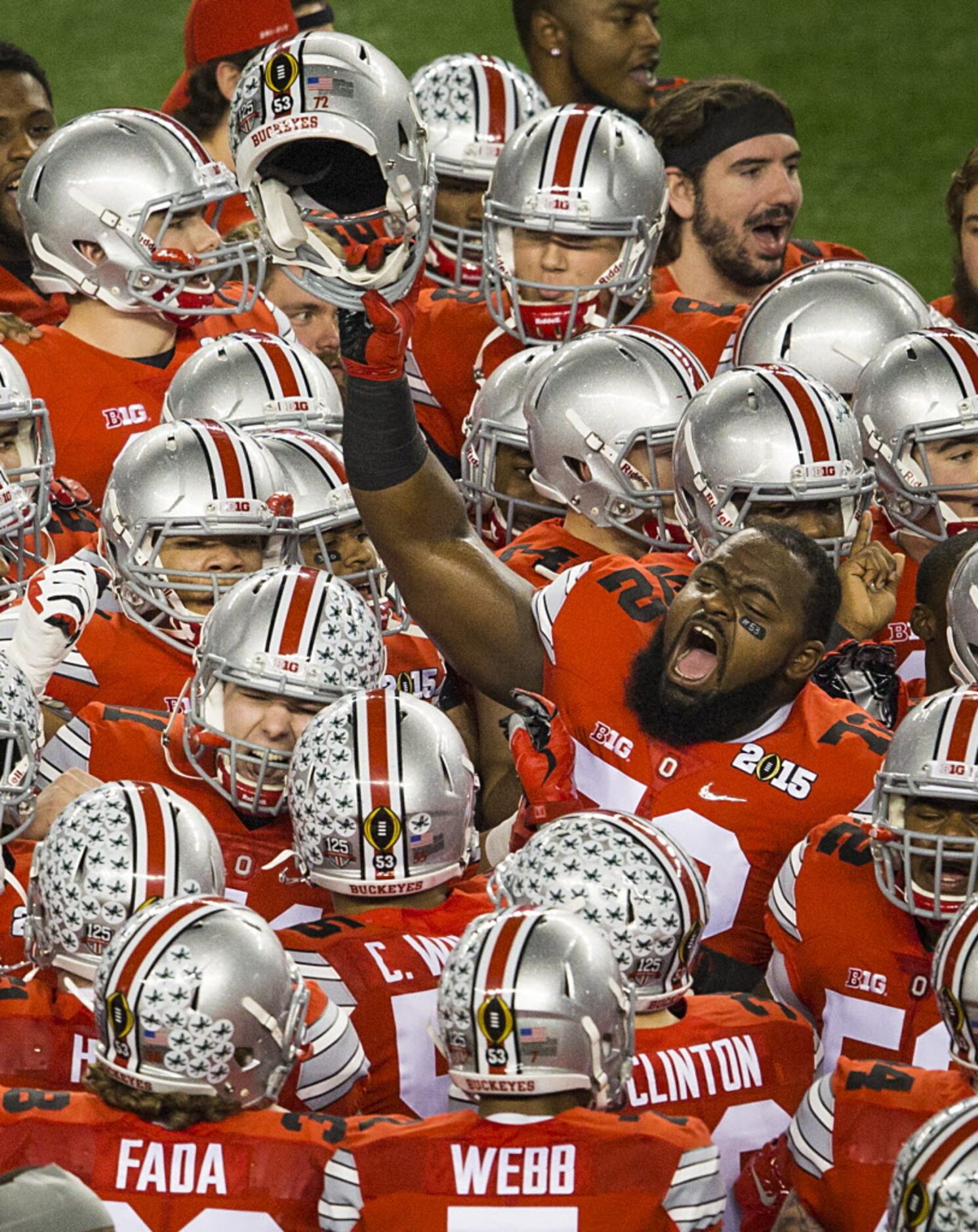 Ohio State Buckeyes players huddle around defensive lineman Chris Carter (72) before the...