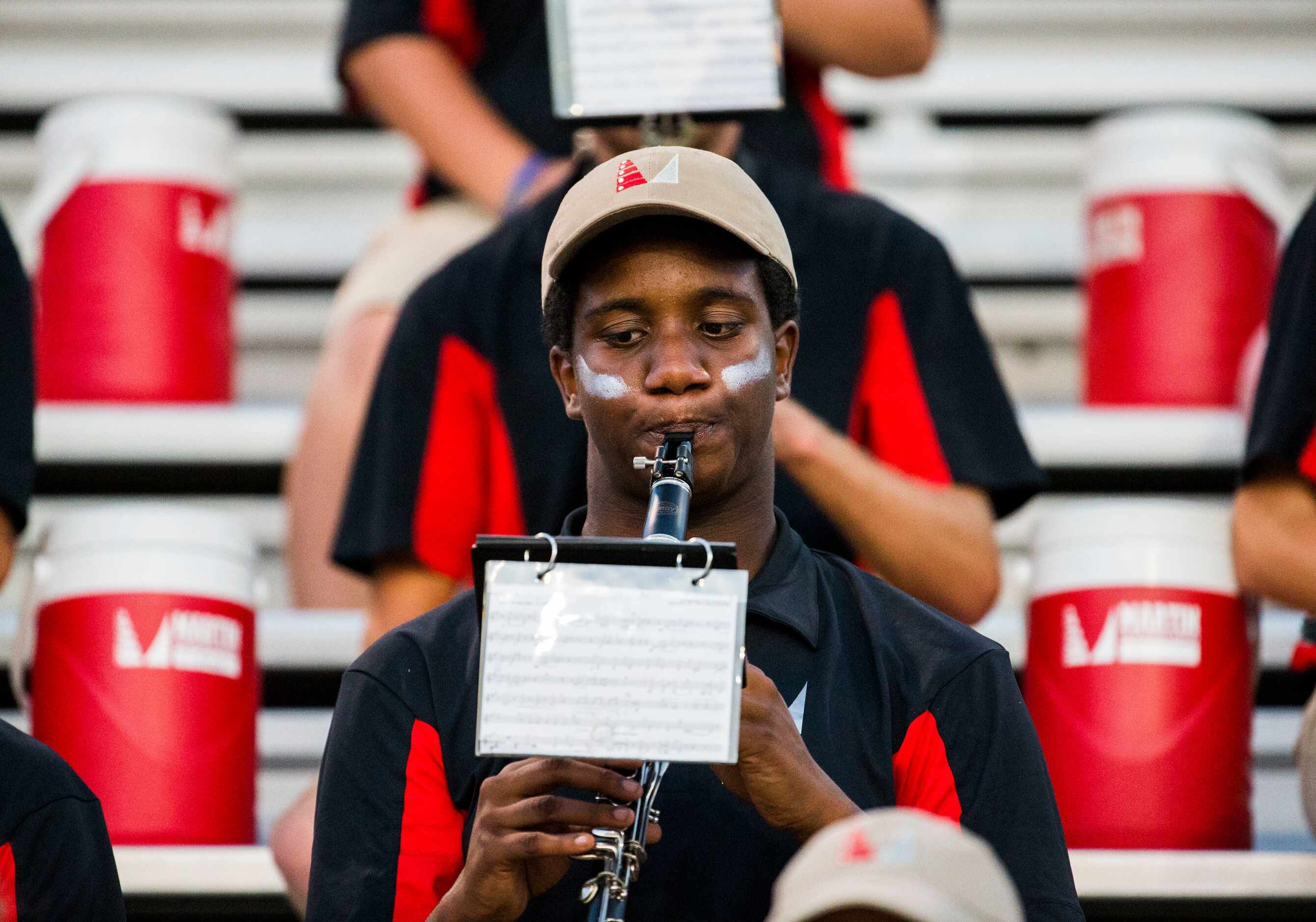 Arlington Martin band member Ben Frazier plays his clarinet in the stands during the first...