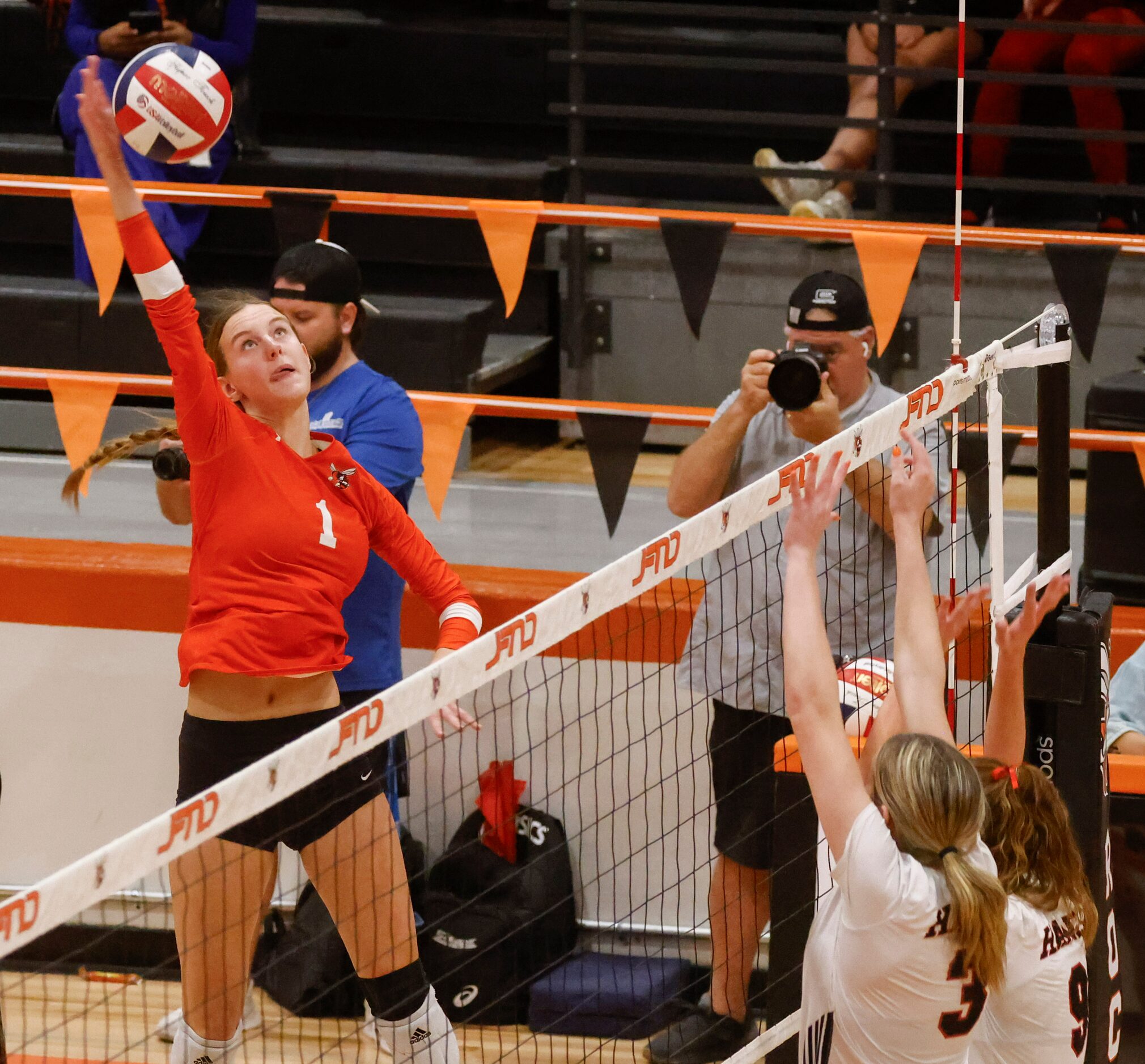 Rockwall high’s Halle Jameson (left) spikes the ball against Rockwall Heath’s Dakoda Hood...