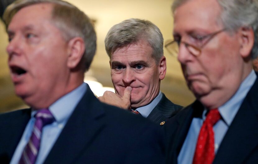 Sen. Bill Cassidy, R-La. (center) listens as Sen. Lindsey Graham, R-S.C., speaks,...