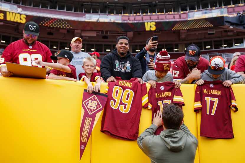 Washington Commanders quarterback Sam Howell (14) signs memorabilia for fans before a NFL...