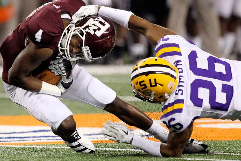 Texas A&M's Brandal Jackson (4) is brought down by LSU's Tharold Simon (26) in the second...
