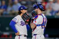 Texas Rangers starter Michael Lorenzen, left, and catcher Jonah Heim, right, talk on the...