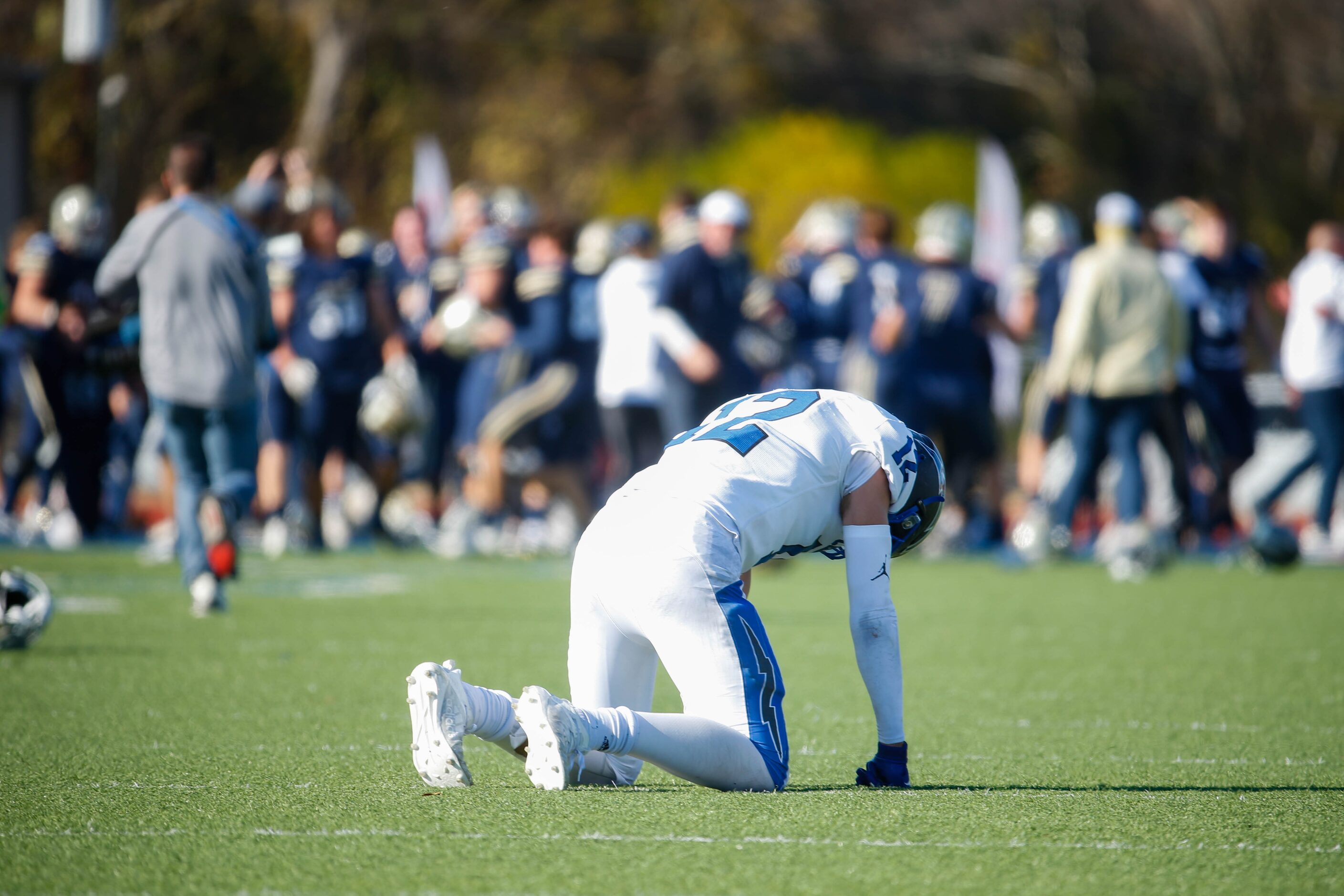 Dallas Christian's Brett Judd (12) kneels as Austin Regents players celebrate in the end...