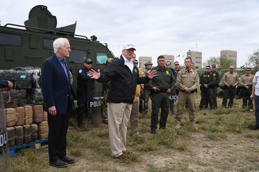 President Donald Trump stands next to Sen. John Cornyn (left) as he speaks to Border Patrol...