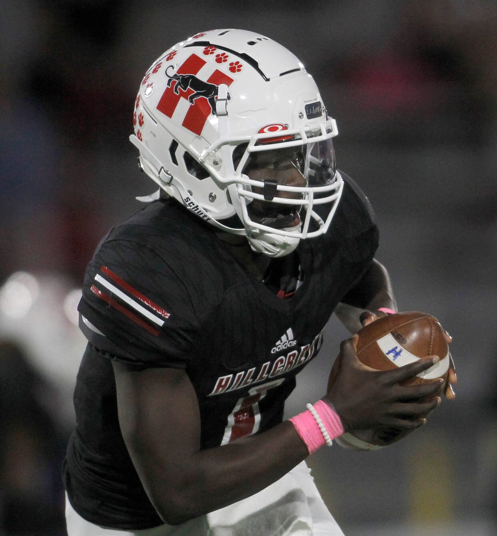 Dallas Hillcrest quarterback Carter Sido (1) rolls out as he looks to pass during the first...