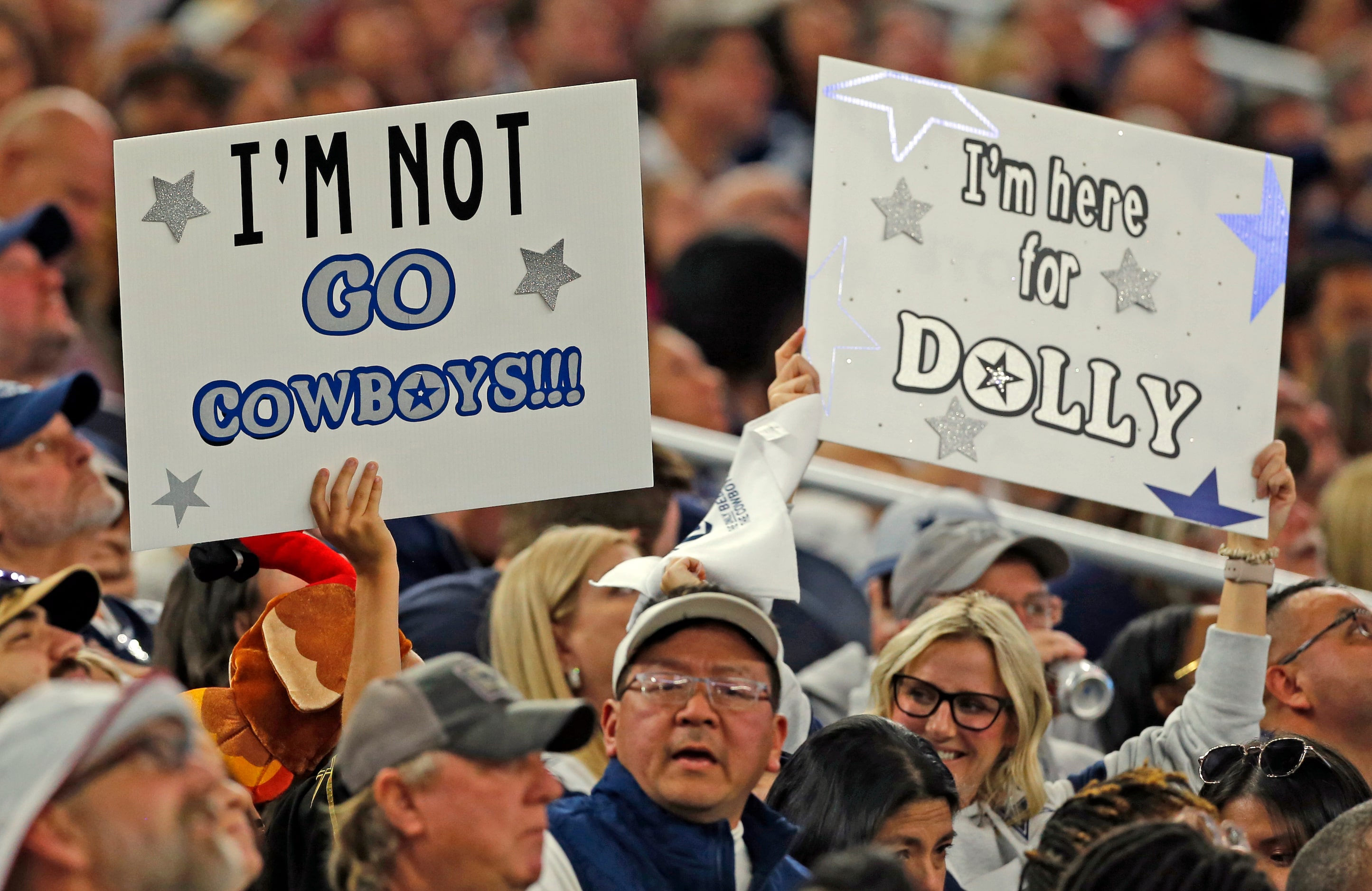 A family with battling signs is shown in the stands during the first half of a NFL football...