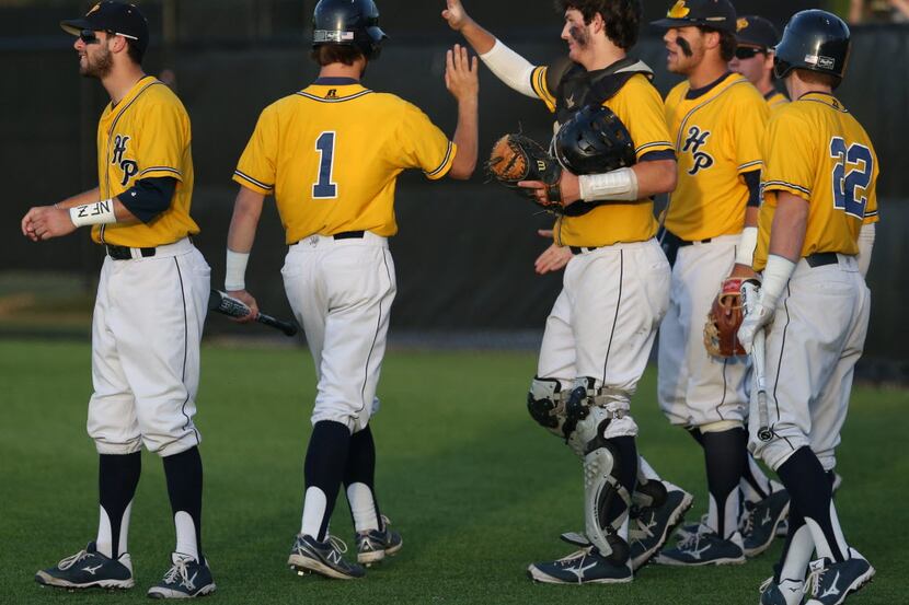 Highland Park's Austin Harrison (1) greets teammates after scoring the first run of the game...