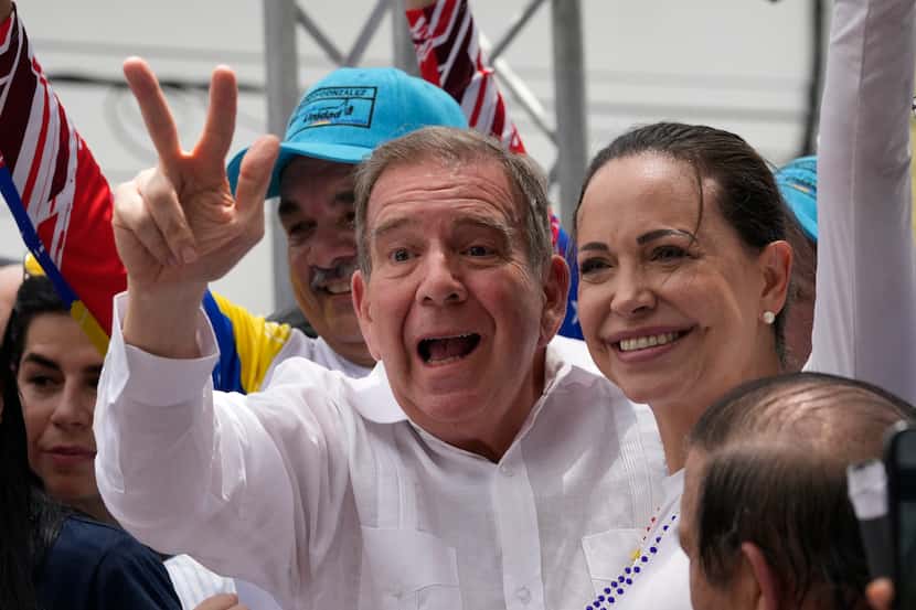 Edmundo González Urrutia flashes a V hand sign accompanied by opposition leader Maria Corina...