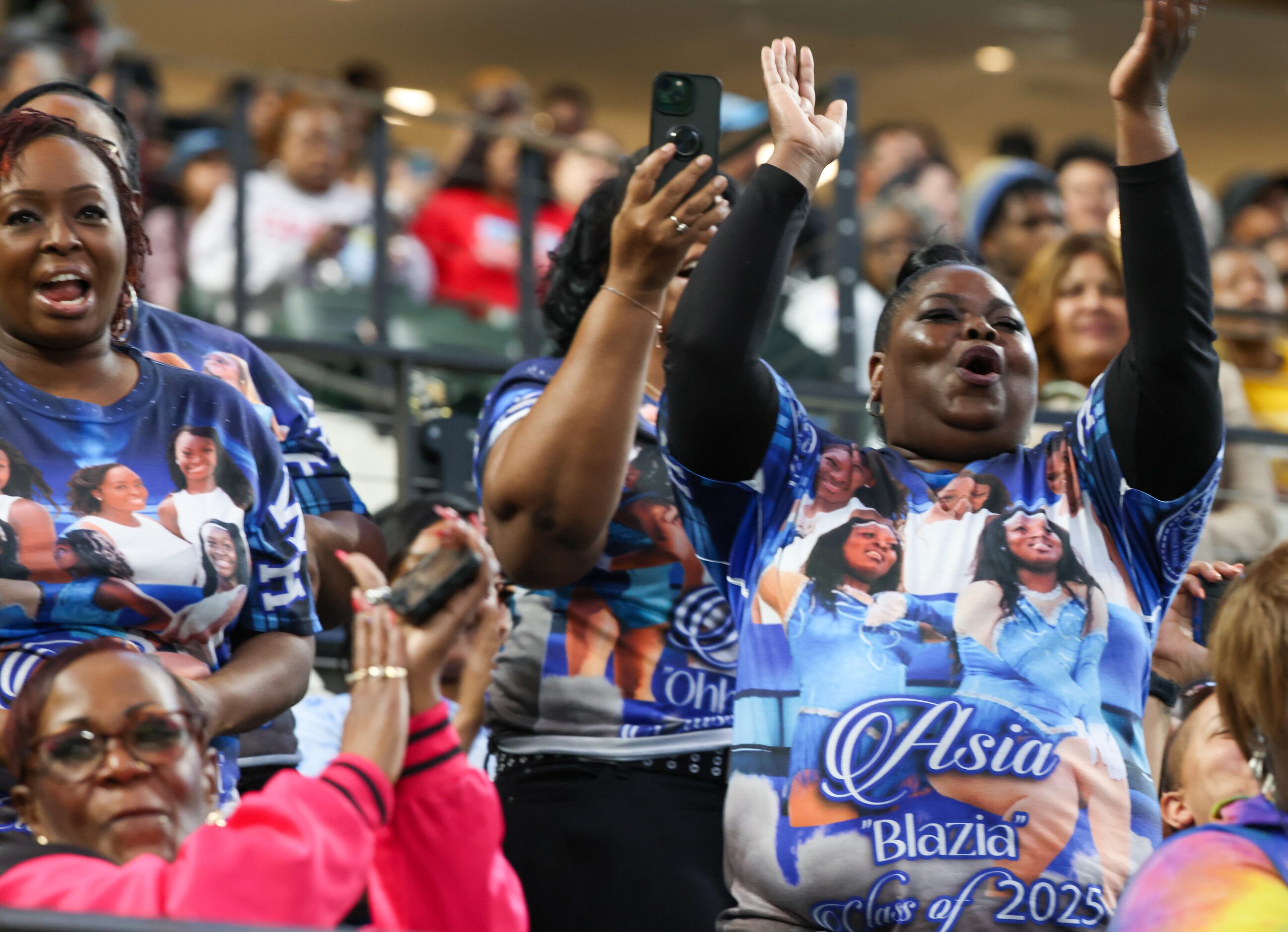 Members of the crowd cheer for Wilmer-Hutchins High School marching band at the Roland...