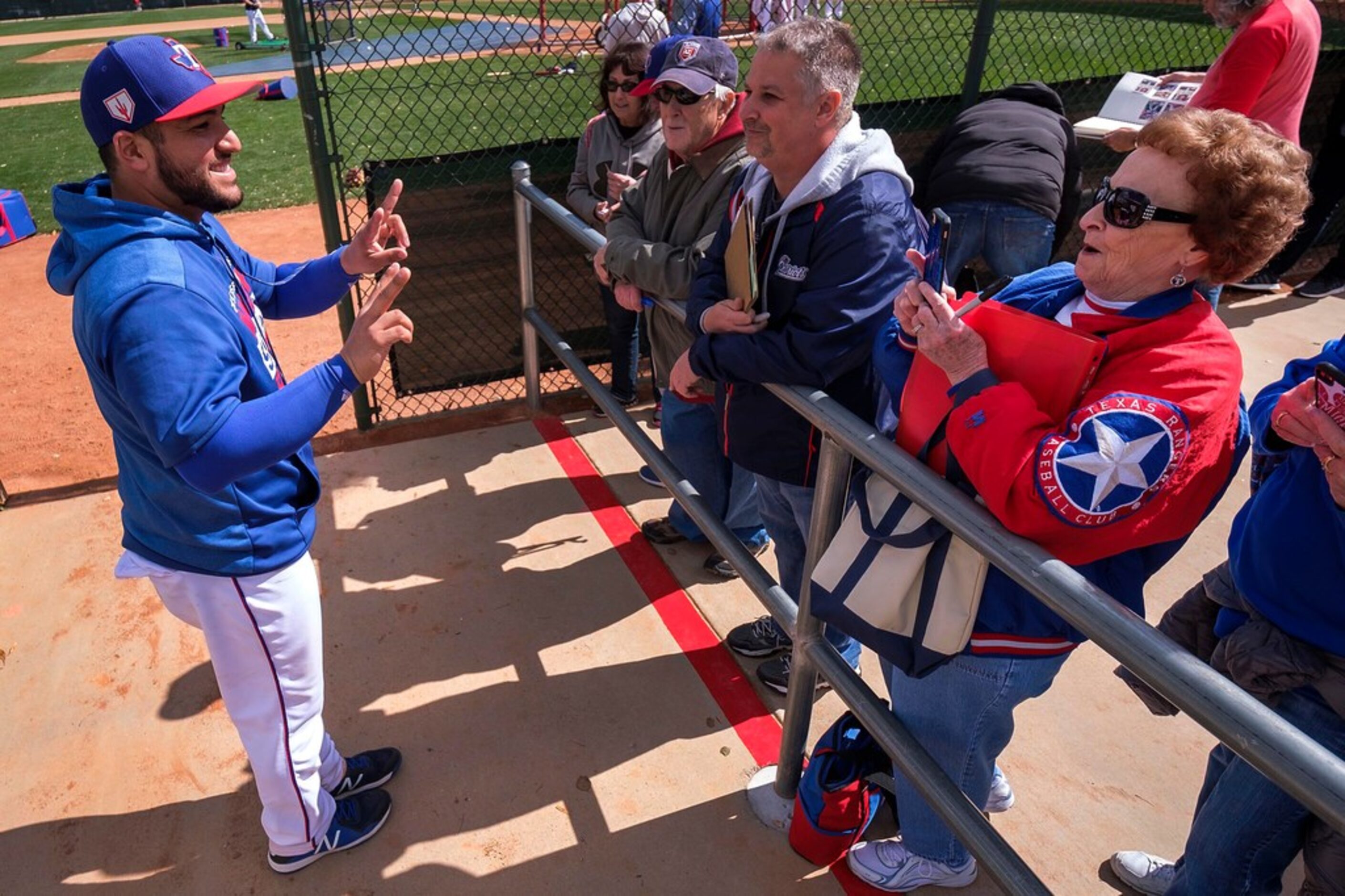 Texas Rangers catcher Jose Trevino poses for Rangers fan Shirley Kost following the first...