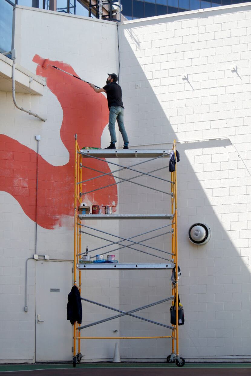 Kyle Steed works on his mural at the Plaza of the Americas.