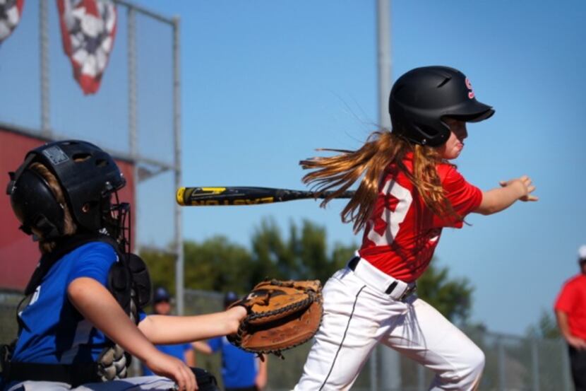 Addison McGowan, 10, prepares to jolt to first base after making contact at the plate during...