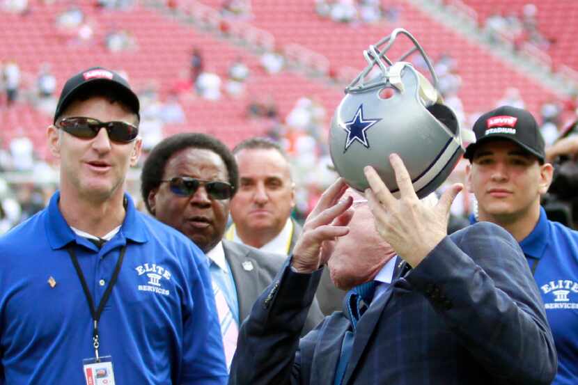 Dallas Cowboys owner and general manager Jerry Jones gets hit by a helmet a fan threw for...