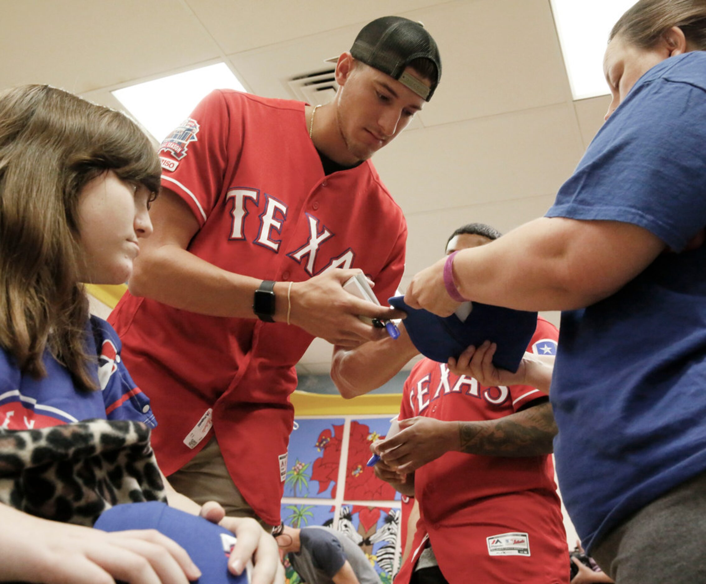 Texas Rangers pitcher Brett Martin signs a hat for 12-year-old Ryley Ashford at Medical City...