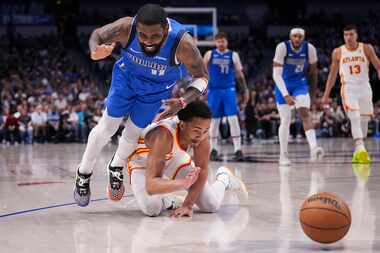 Dallas Mavericks guard Kyrie Irving (11) collides with Atlanta Hawks guard Kobe Bufkin (4)...