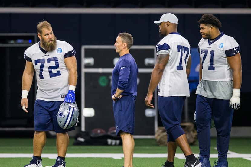 Dallas Cowboys center Travis Frederick (72) talks with offensive tackle Tyron Smith (77) and...