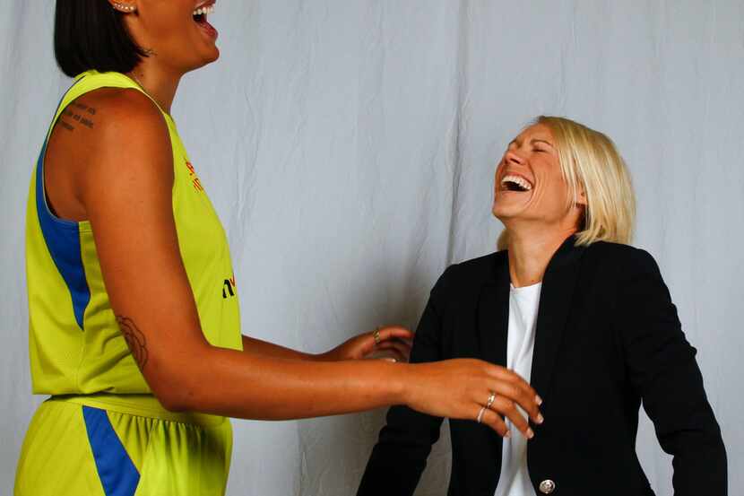 Dallas Wings center Liz Cambage (8) and assistant coach Erin Phillips share a laugh as they...