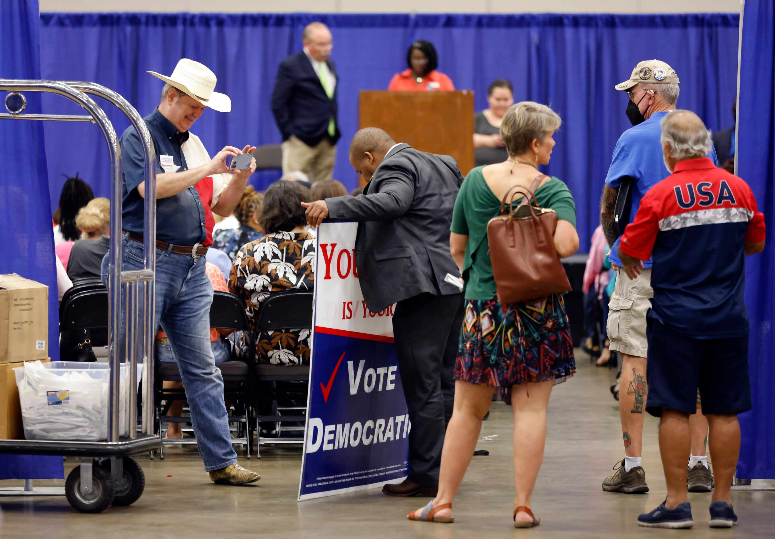 Steven Spainhouer (left) of McKinney, Texas takes a photo of his big voting sign he brought...