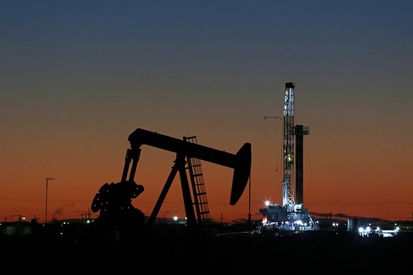 FILE photo shows an oil rig and pump jack at work in Midland, Texas. (Jacob Ford/Odessa...