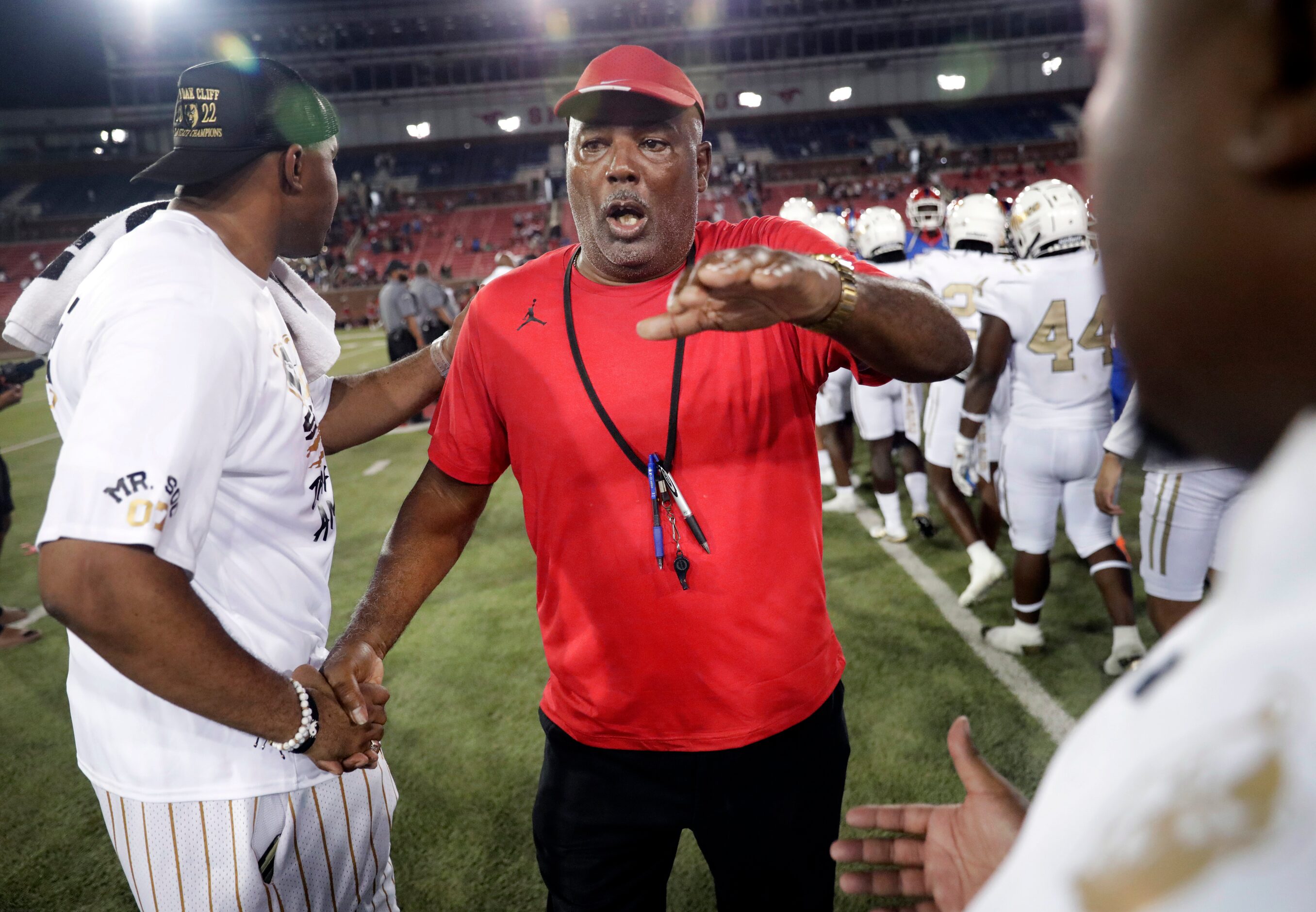 Duncanville head coach Reginald Samples (center) wishes the South Oak Cliff coaching staff...