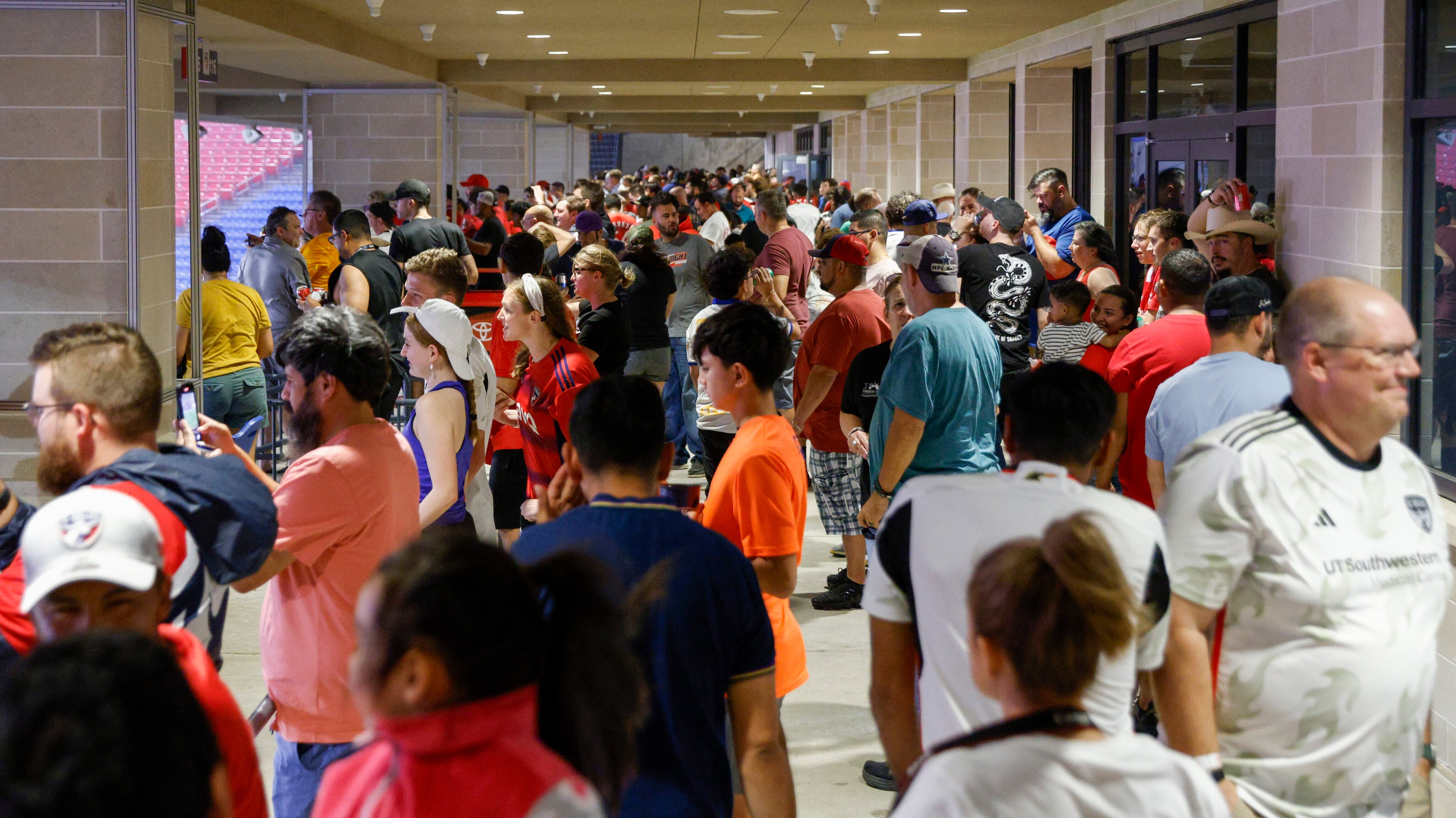 Fans avoid the rain on the concourse during a lightning delay before an MLS game between FC...