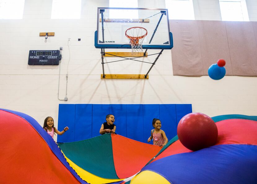 Kindergarteners play a parachute game during the camp.