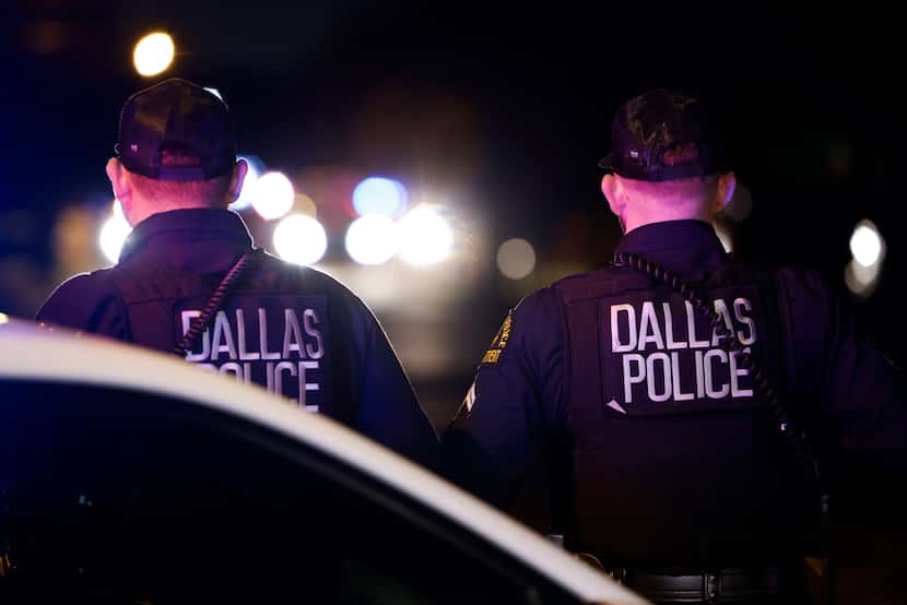 Oficiales del Departamento de la Policía de Dallas en la escena de un crimen donde murieron...