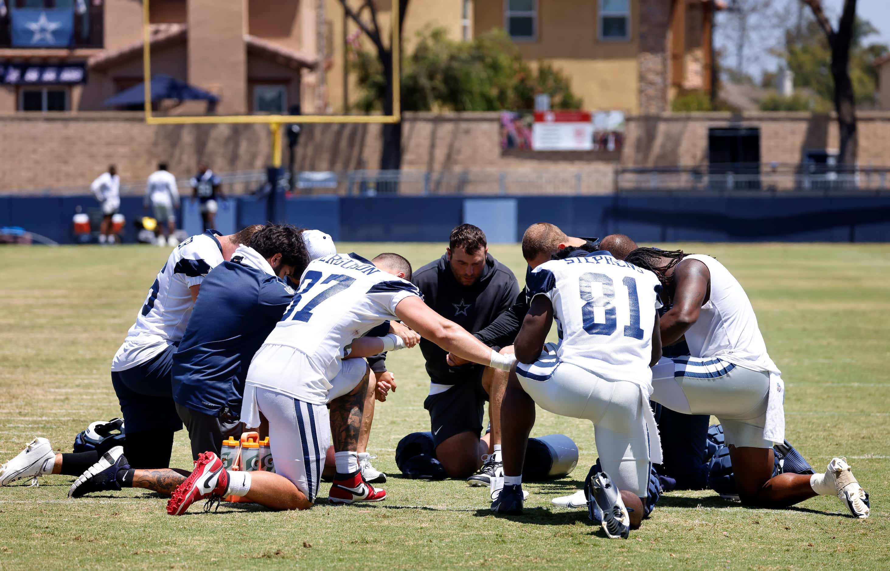 Dallas Cowboys tight ends and coaches circled for prayer following training camp practice in...