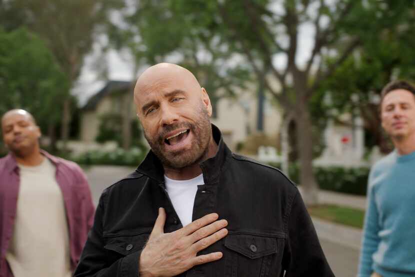 John Travolta (center) sings in T-Mobile's Super Bowl commercials as Zach Braff and Donald...