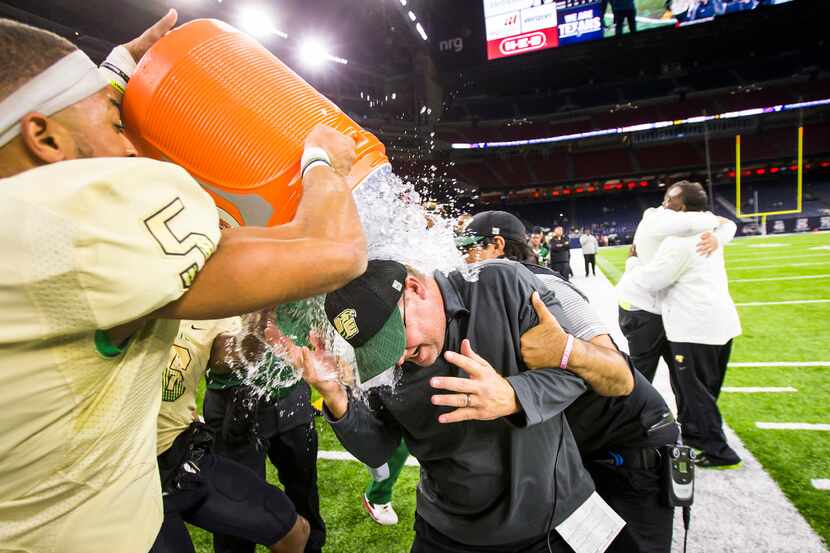 DeSoto head coach Todd Peterman  is doused with water by defensive back Byron Hanspard Jr....