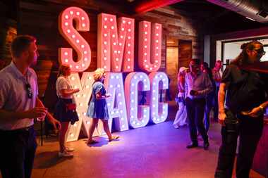 SMU supporters and alumni walk past a SMU and ACC sign during a celebration of SMU’s first...