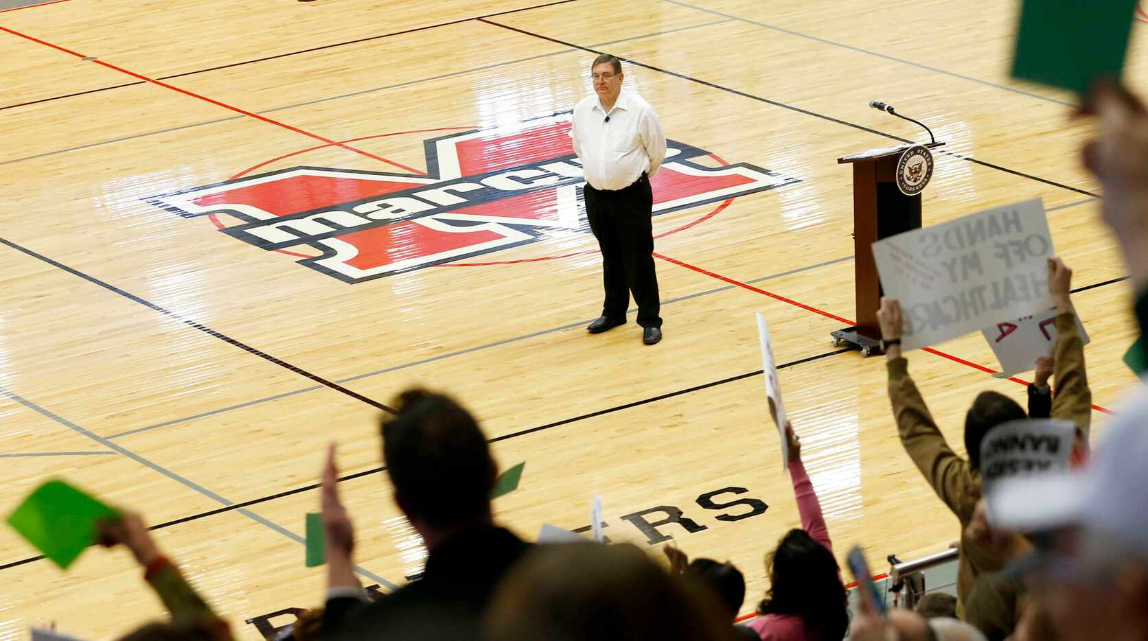 Congressman Michael Burgess listens to a question during a town hall meeting at Marcus High...