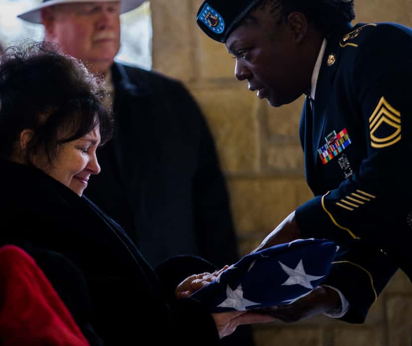 Eva Arnold is presented with an American flag that was draped on a casket containing the...