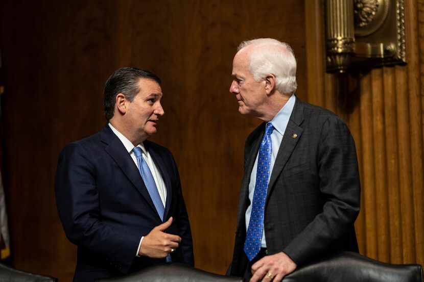 Sen. Ted Cruz, R-Texas, talks with Sen. John Cornyn, R-Texas, during a break in hearing...