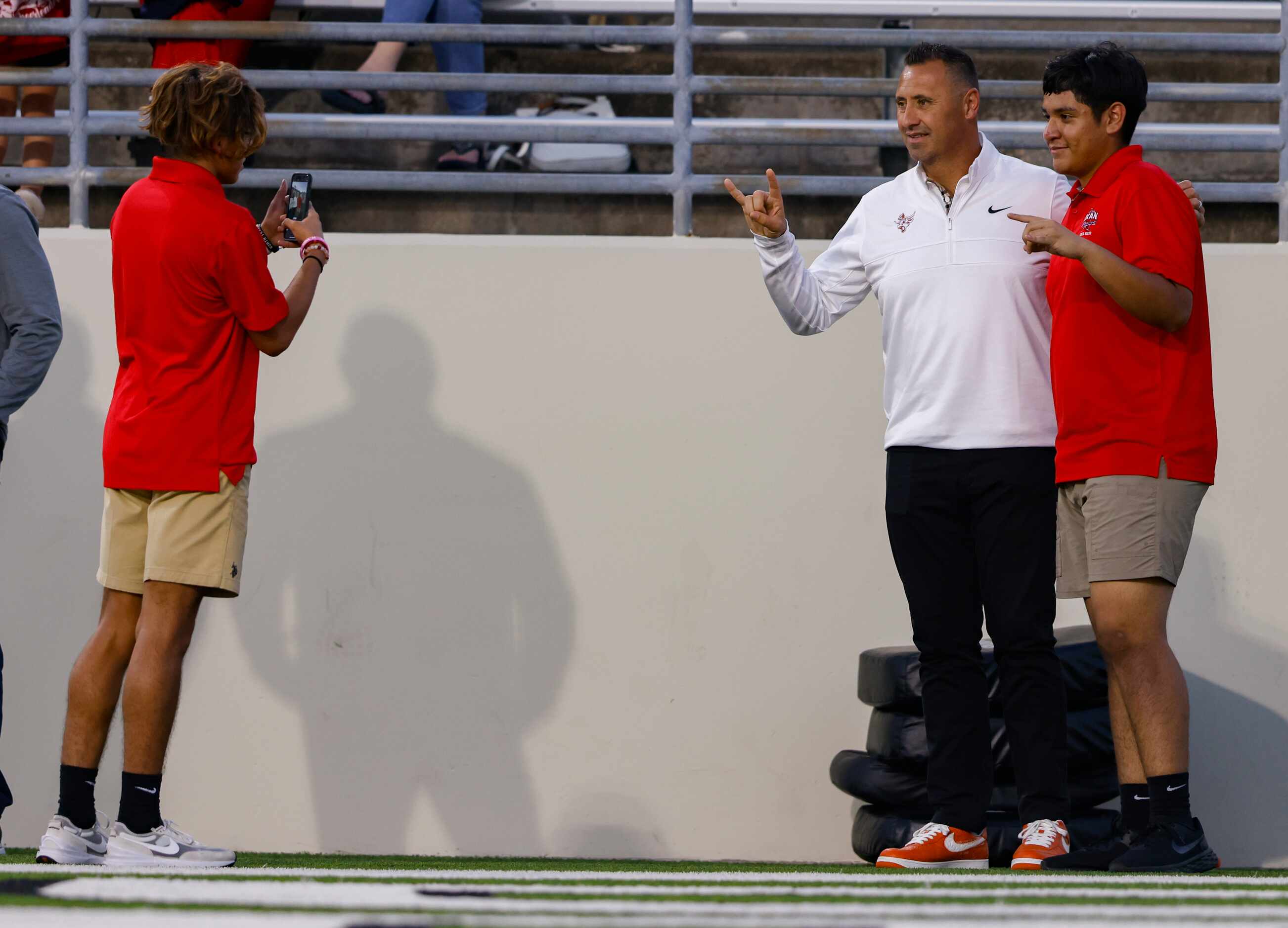 The University of Texas at Austin football head coach Steve Sarkisian (second to left) takes...