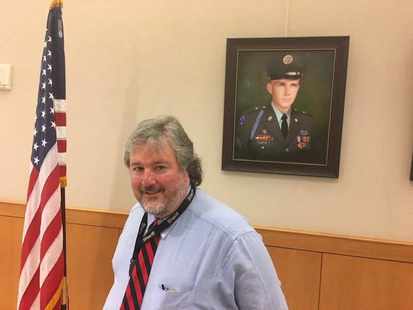 Artist Colin Kimball stands before a portrait he painted of Joe Huston, 20, killed in action...