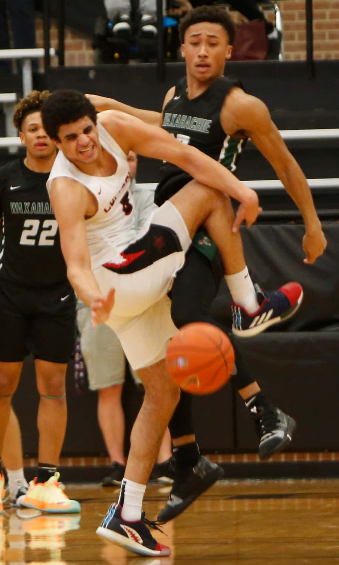 Coppell guard Adam Moussa (5), left, tangles with Waxahachie guard Preston Hodge (13) as the...