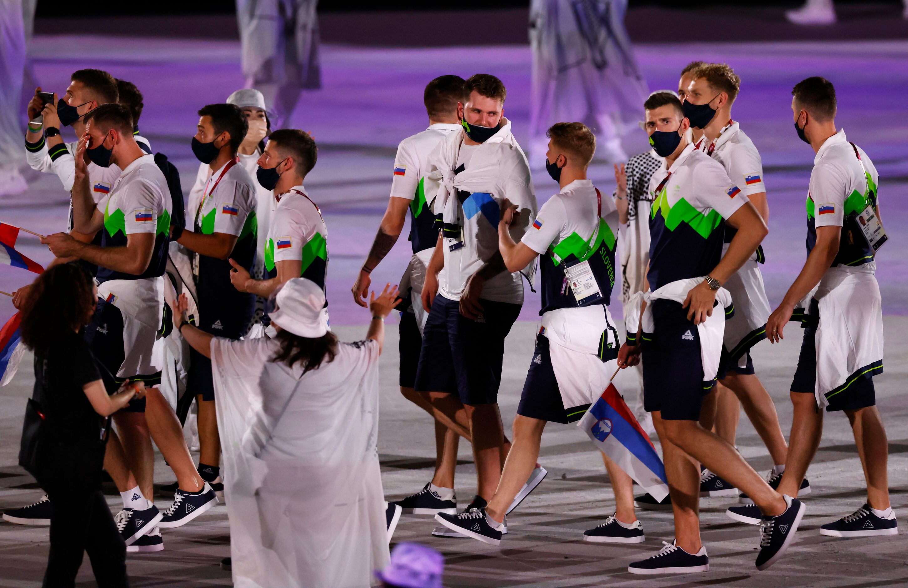 Slovenia’s Luka Doncic walks across the stage with fellow Slovenian Olympic athletes during...