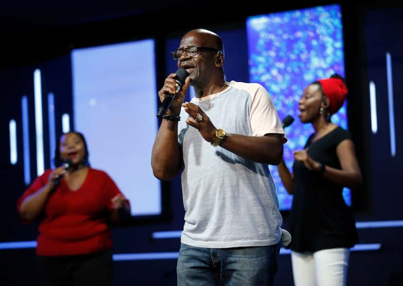 Ivan Tucker leads the praise team in song with Candice Bryant (left) and Monisha Randolph...