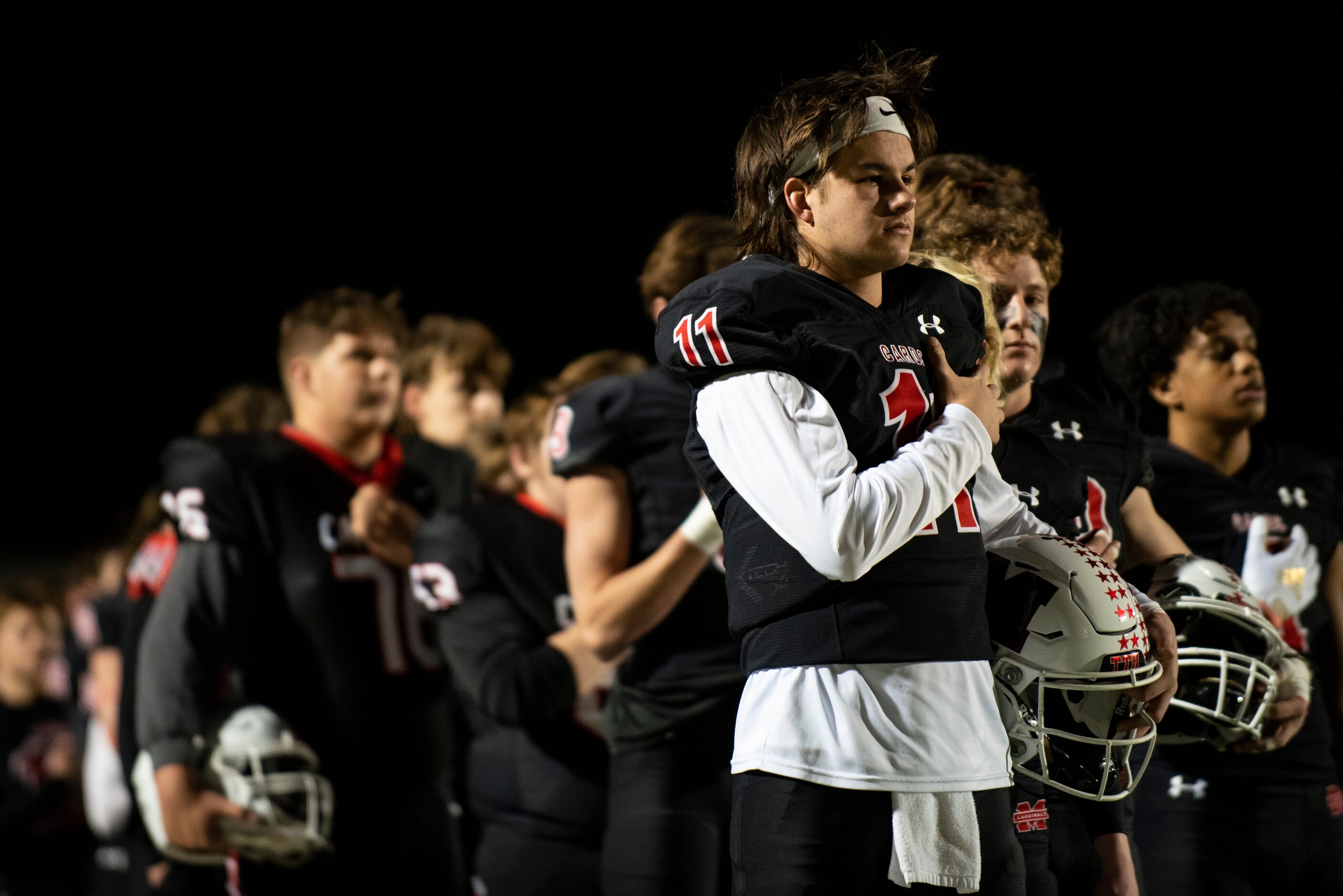 Melissa senior Sam Fennegan (11) holds his hand over his heart prior to the start of the...