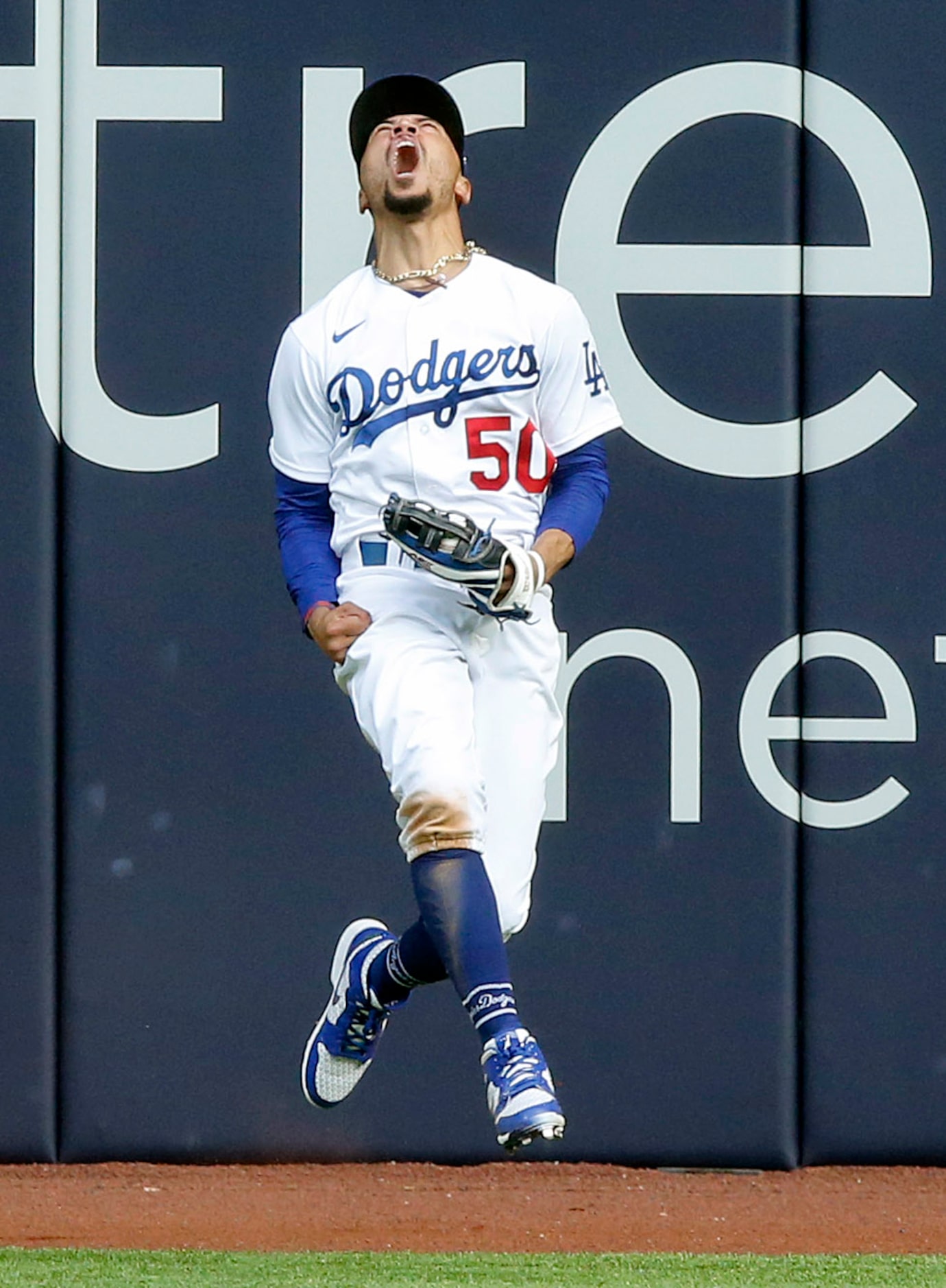 Los Angeles Dodgers right fielder Mookie Betts (50) reacts after leaping and catching a deep...