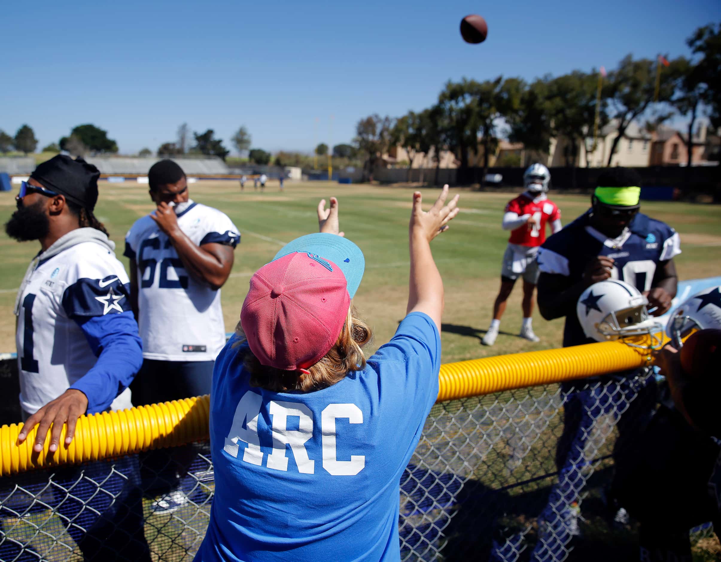 Dallas Cowboys quarterback Dak Prescott (4) plays catch with a volunteer following their...