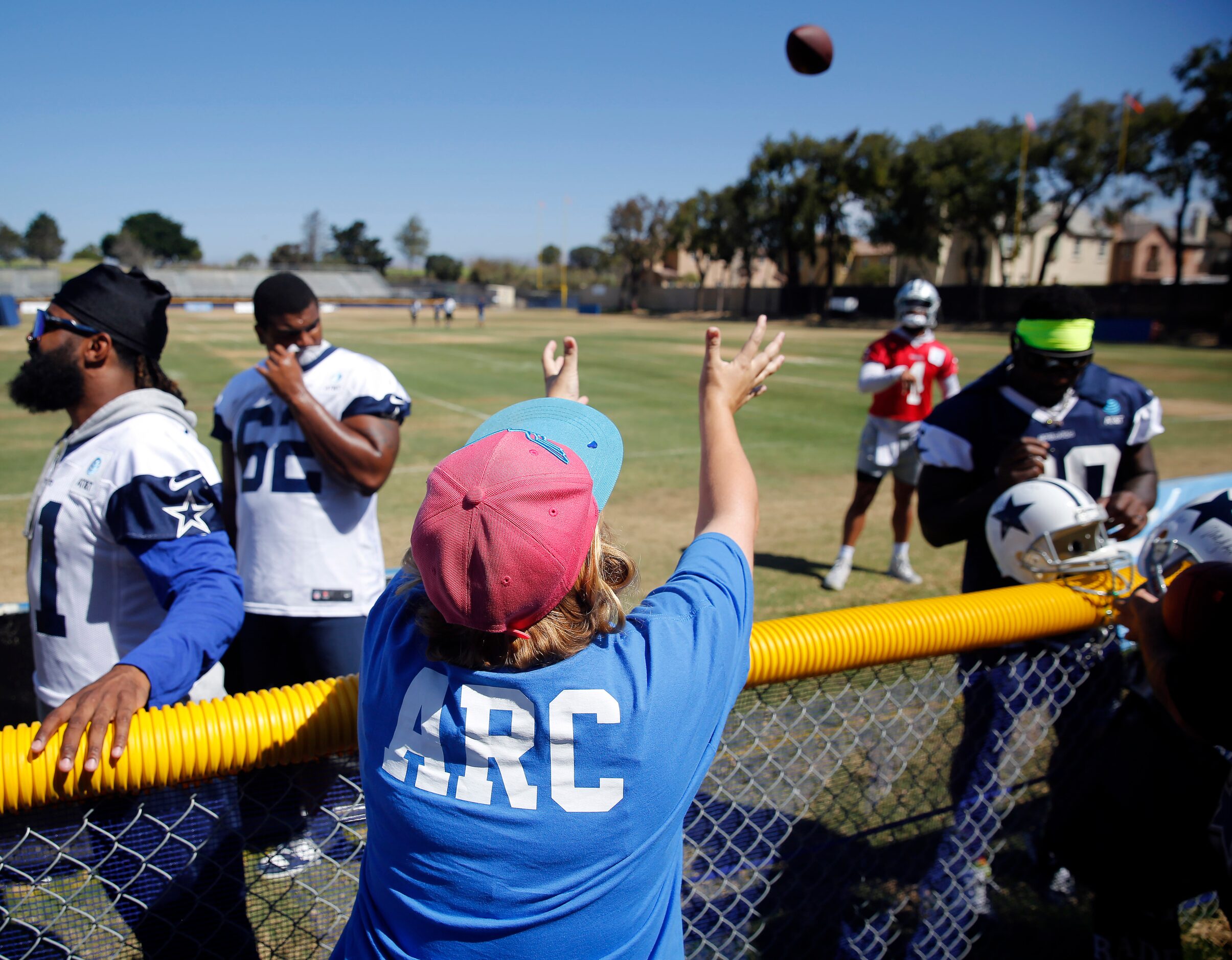 Dallas Cowboys quarterback Dak Prescott (4) plays catch with a volunteer following their...