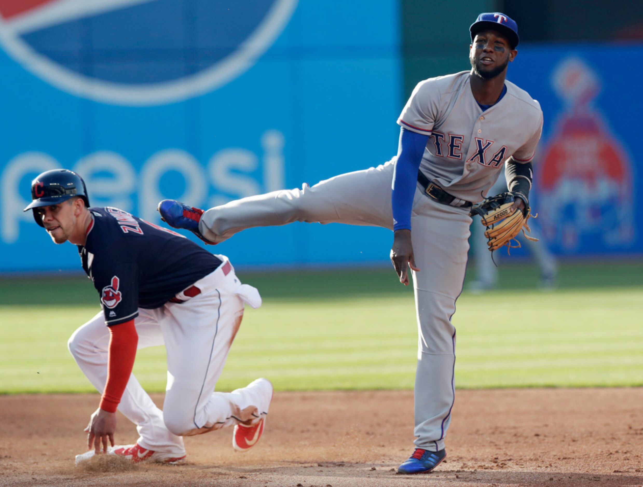 Texas Rangers' Jurickson Profar, right, looks toward first base after getting Cleveland...