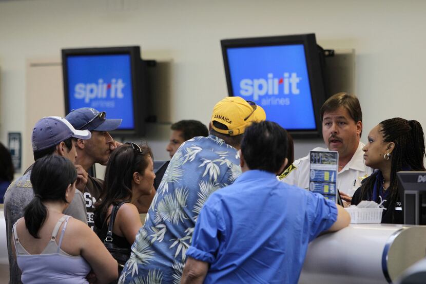 FILE - In this June 12, 2010, file photo, stranded passengers stand at the Spirit Airlines...
