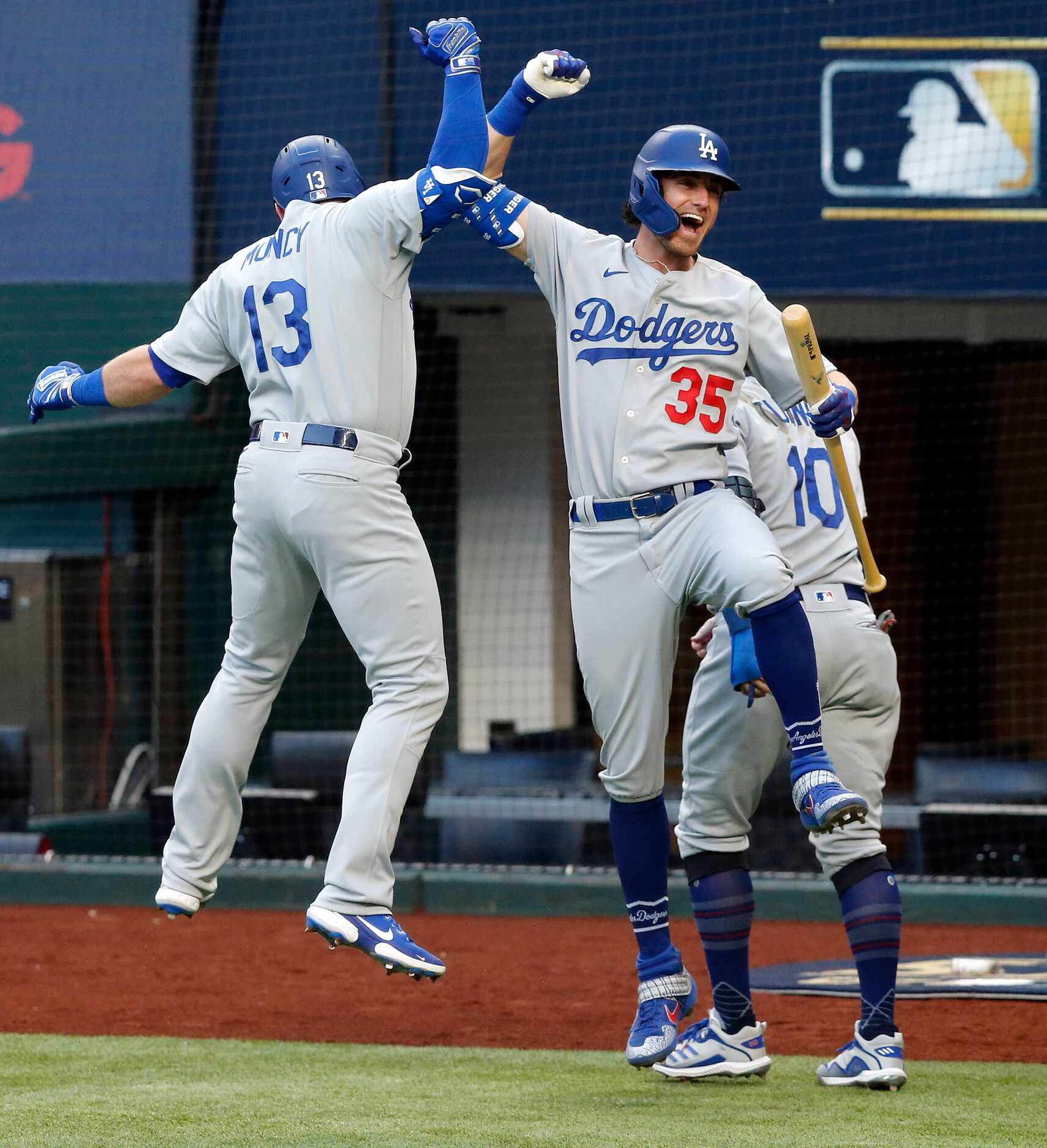 Los Angeles Dodgers Cody Bellinger (35) congratulates Max Muncy (13) on his first inning...