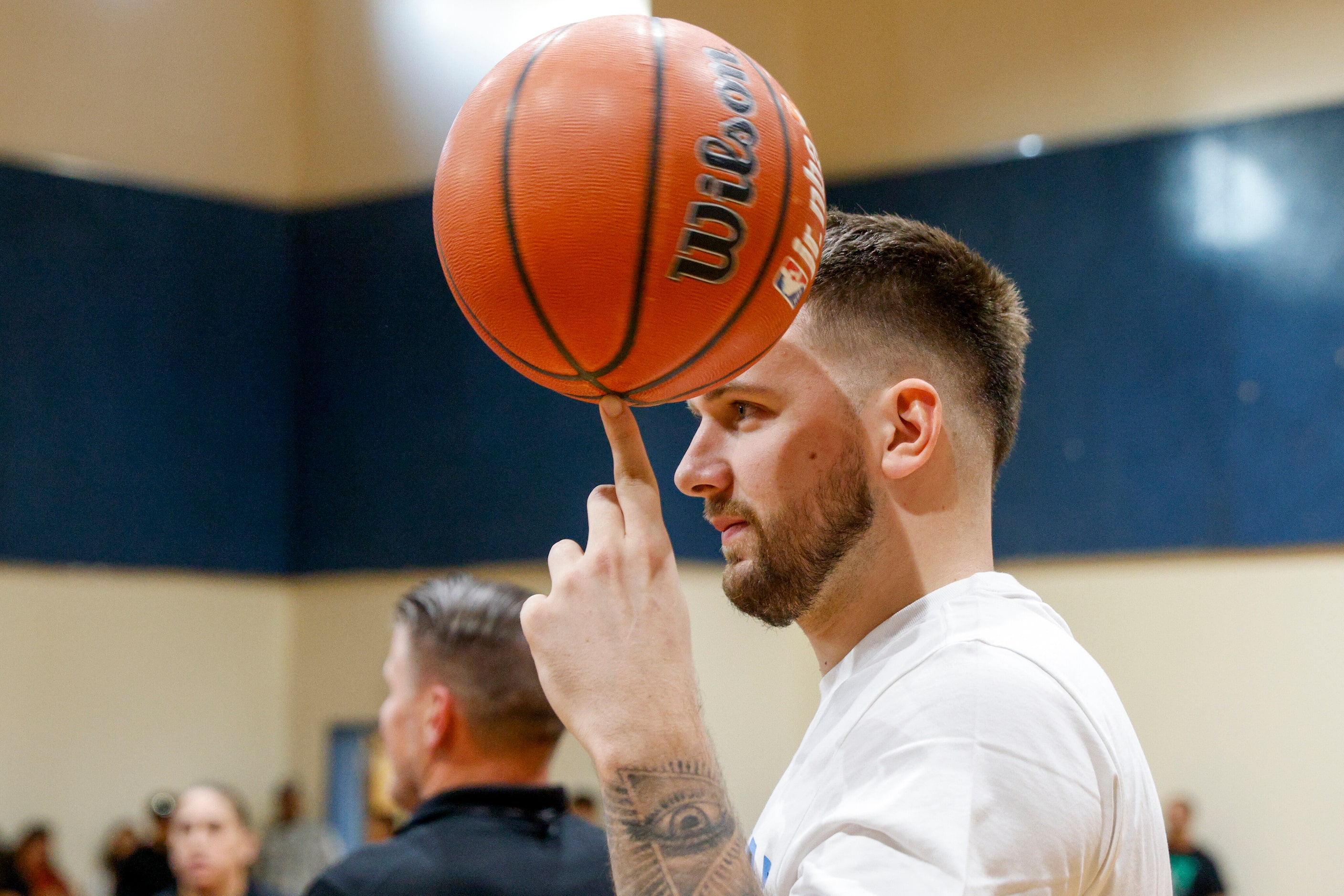 Dallas Mavericks guard Luka Doncic spins a basketball on his finger during a children’s...