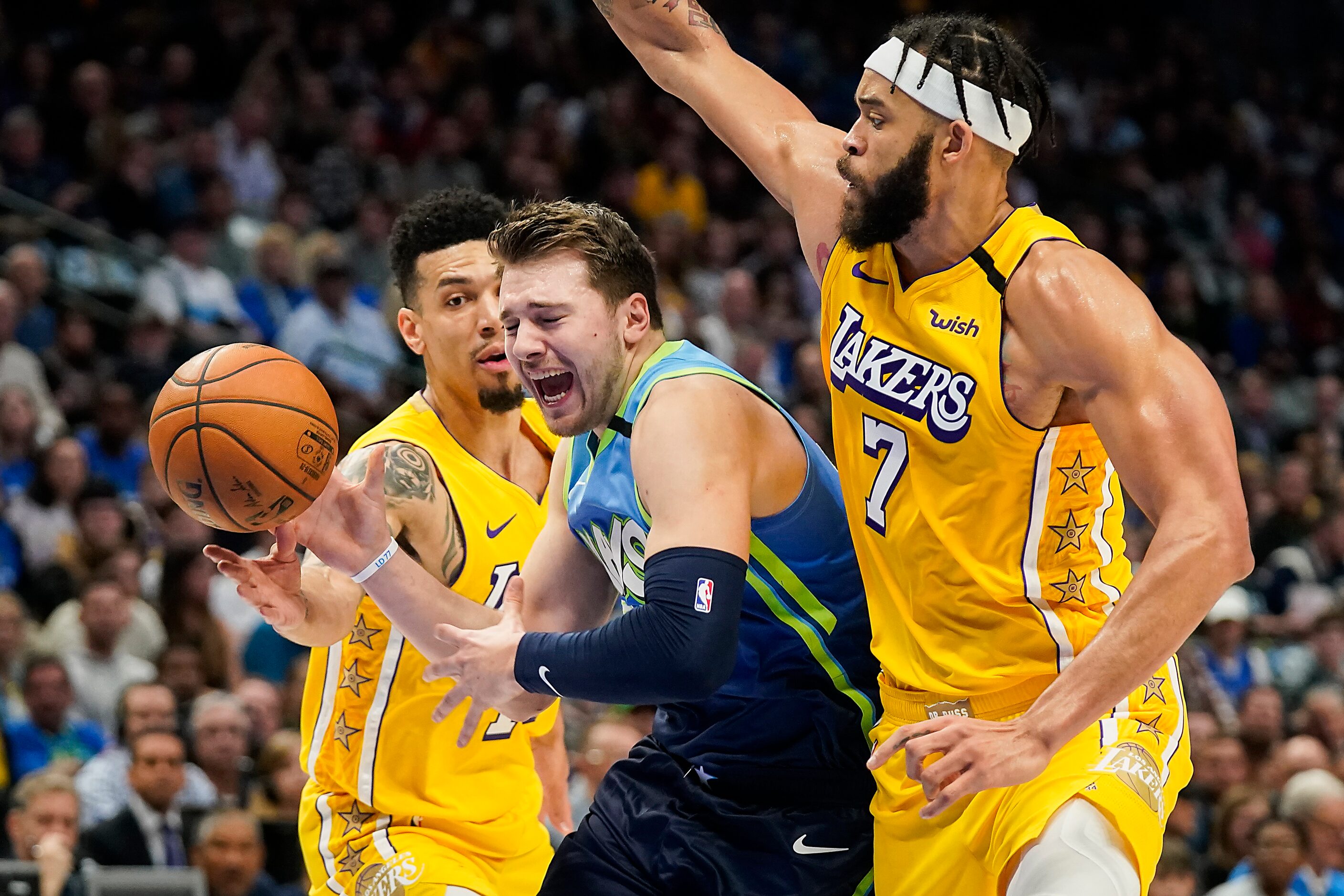 Dallas Mavericks guard Luka Doncic (77) loses the ball as he drives between Los Angeles...