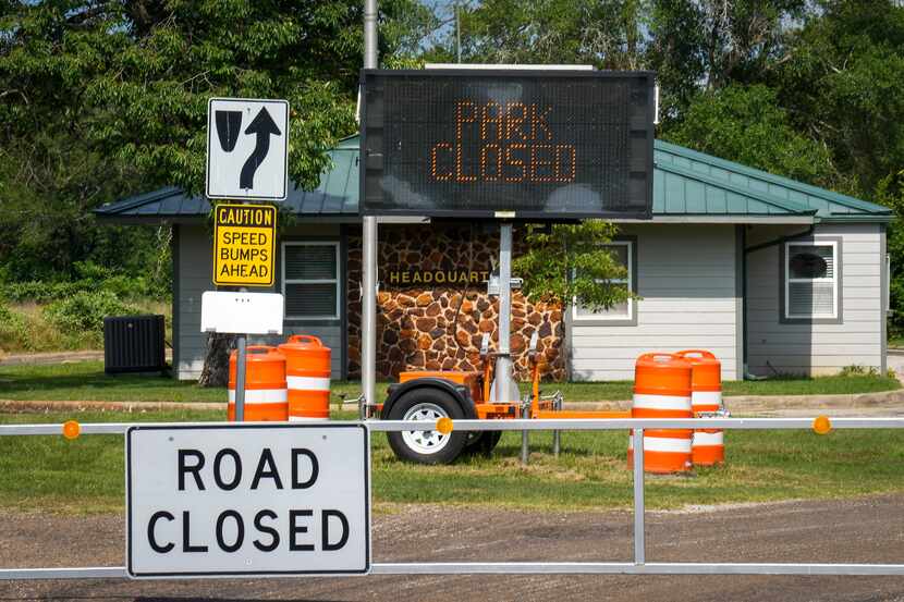 Signs mark the park closed at the locked gate of Fairfield Lake State Park on Monday, June...